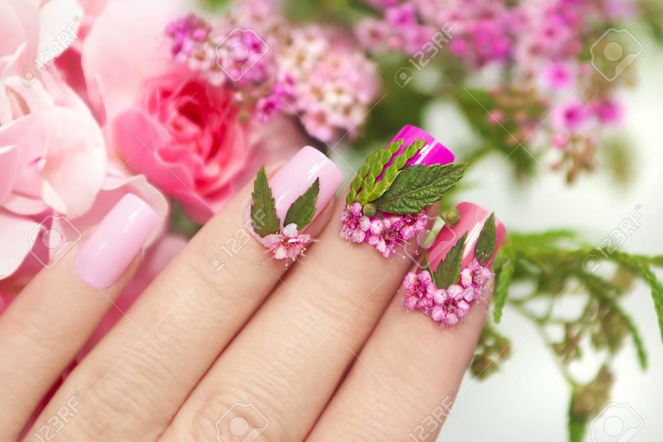 女性の手に自然の花のデザインと色とりどりのパステル マニキュアをクローズ アップ 夏ネイル デザイン の写真素材 画像素材 Image