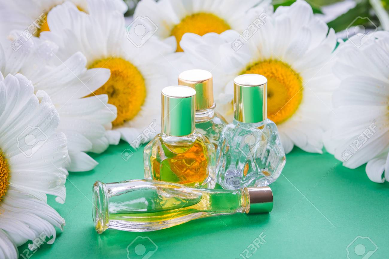 緑色の背景にカモミールと香水のボトル の写真素材 画像素材 Image