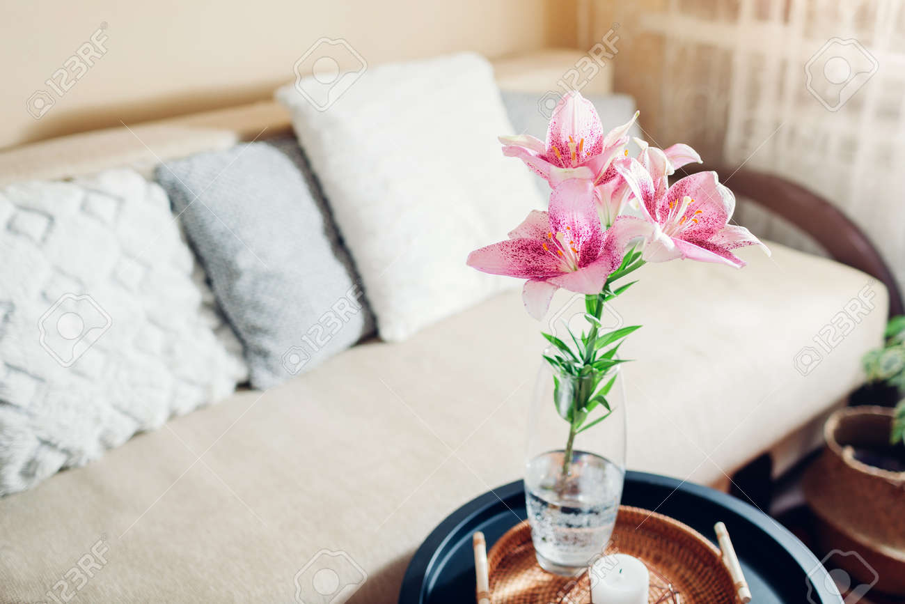 Interior and home decor. Fresh pink lily flowers put in vase in living room by couch. Bouquet of blooms on coffee table - 171922006 Interior and home decor. Fresh pink lily flowers put in vase in living room by couch. Bouquet of blooms on coffee table - 171922006