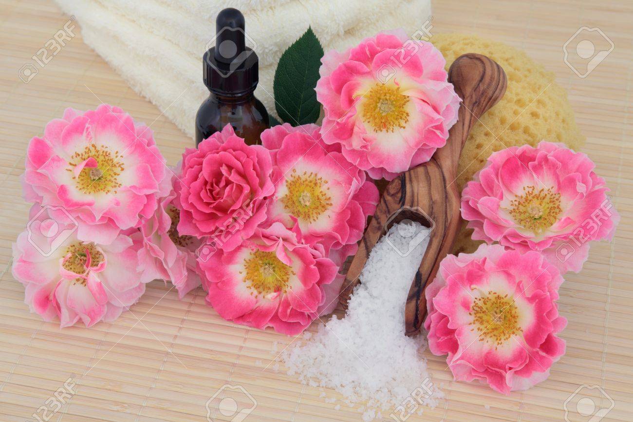 アロマセラピーのエッセンシャル オイルのボトル 海の塩 スポンジおよびタオル スタックの気楽な日々 の様々 なバラ フラワーアレンジメント スパ の写真素材 画像素材 Image
