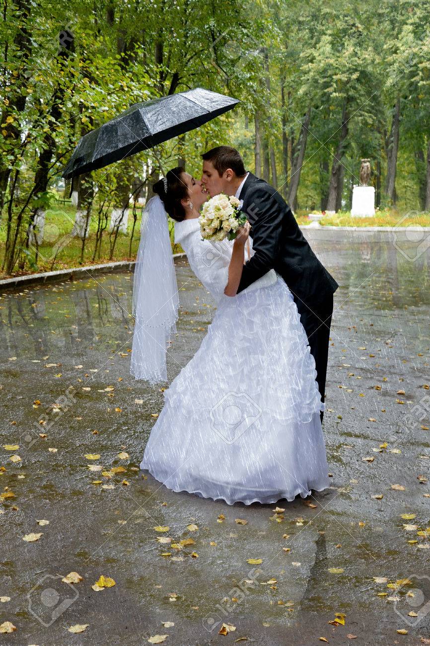 Beautiful Wedding Couple Kissing In The Rain Bride And Groom Walking In The Park Under An Umbrella On A Rainy Day Stock Photo Picture And Royalty Free Image Image