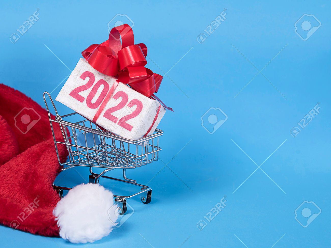 Christmas Shopping 2022 2022 Text On Gift Box With Red Ribborn, Santa Claus Hat And Shopping  Trolley. Blue Background. Christmas And New Year Delivery Concept.  Copyspace. Stock Photo, Picture And Royalty Free Image. Image 162944403.