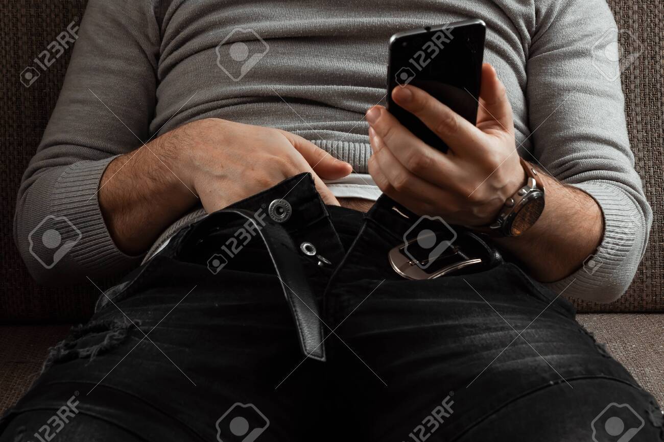 A Man Watches An Adult Video On A Phone While Sitting On A Couch. The  Concept Of Porn, Masturbation, Male Needs, Pervert, Lust, Desire,  Loneliness. Stock Photo, Picture and Royalty Free Image.