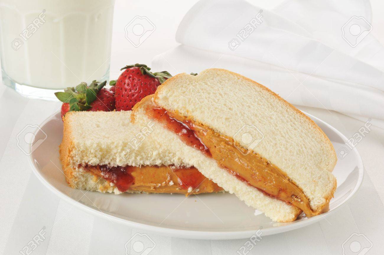 A Peanut Butter And Strawberry Jam Sandwich With Milk On A High