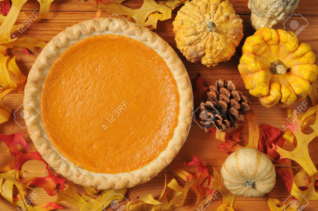 A whole sweet potato pie on an artistic set with autumn leaves, squash and gourds. - 22801941 A whole sweet potato pie on an artistic set with autumn leaves, squash and gourds. - 22801941