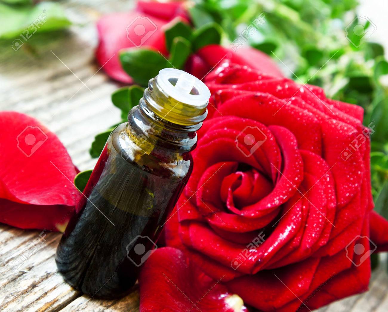 赤いバラのエッセンス アロマテラピー エッセンシャル オイル ボトルの花びらと花を持つ の写真素材 画像素材 Image