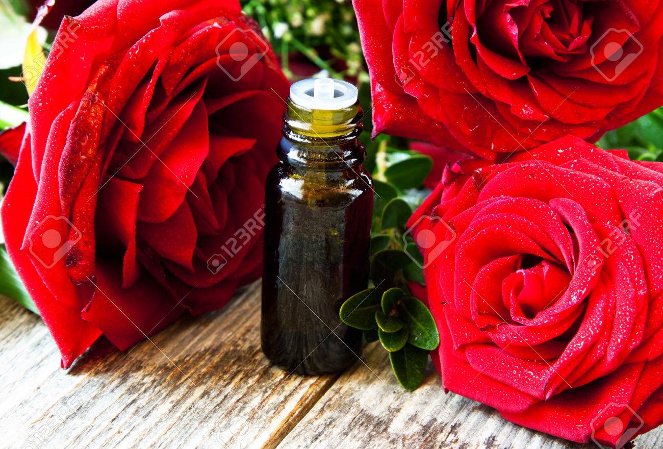 赤いバラのエッセンス アロマテラピーのエッセンシャル オイルのボトルと美しい赤いバラ の写真素材 画像素材 Image