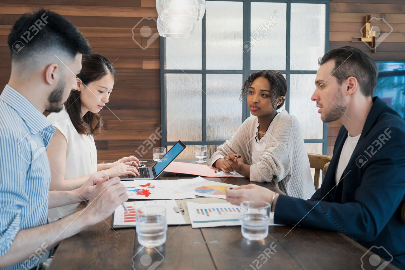 Businessmen of various races meeting in a casual office space - 153629867 Businessmen of various races meeting in a casual office space - 153629867