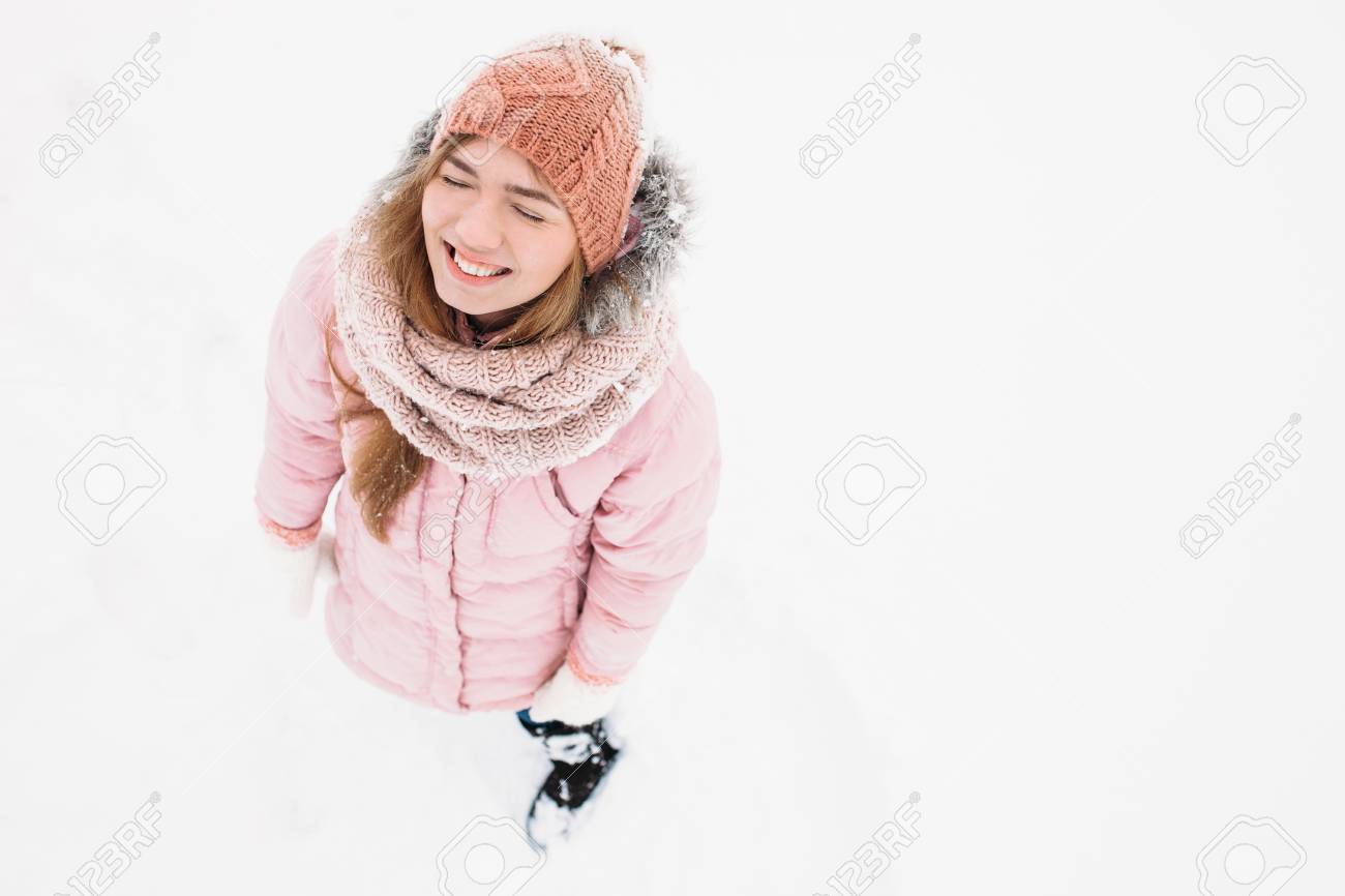 屋外でポーズをとる女の子 寒い天候でスキー服の屋外レクリエーションで笑顔と幸せな若い女性を見上げる女の子 広告のための画像 テキストを挿入 の写真素材 画像素材 Image