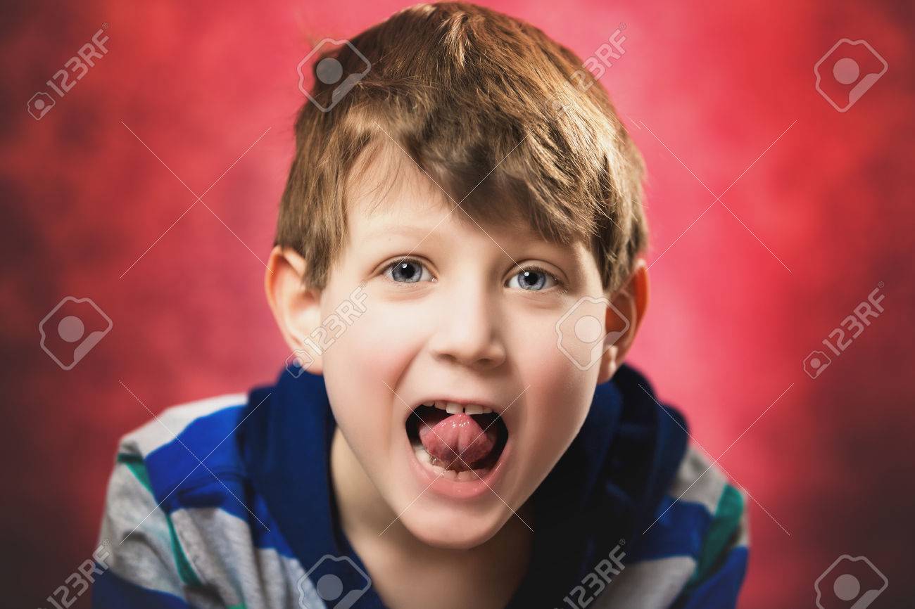 1 7 歳の白人少年ふざけて彼の舌で突き出るカメラ 背景が赤です の写真素材 画像素材 Image