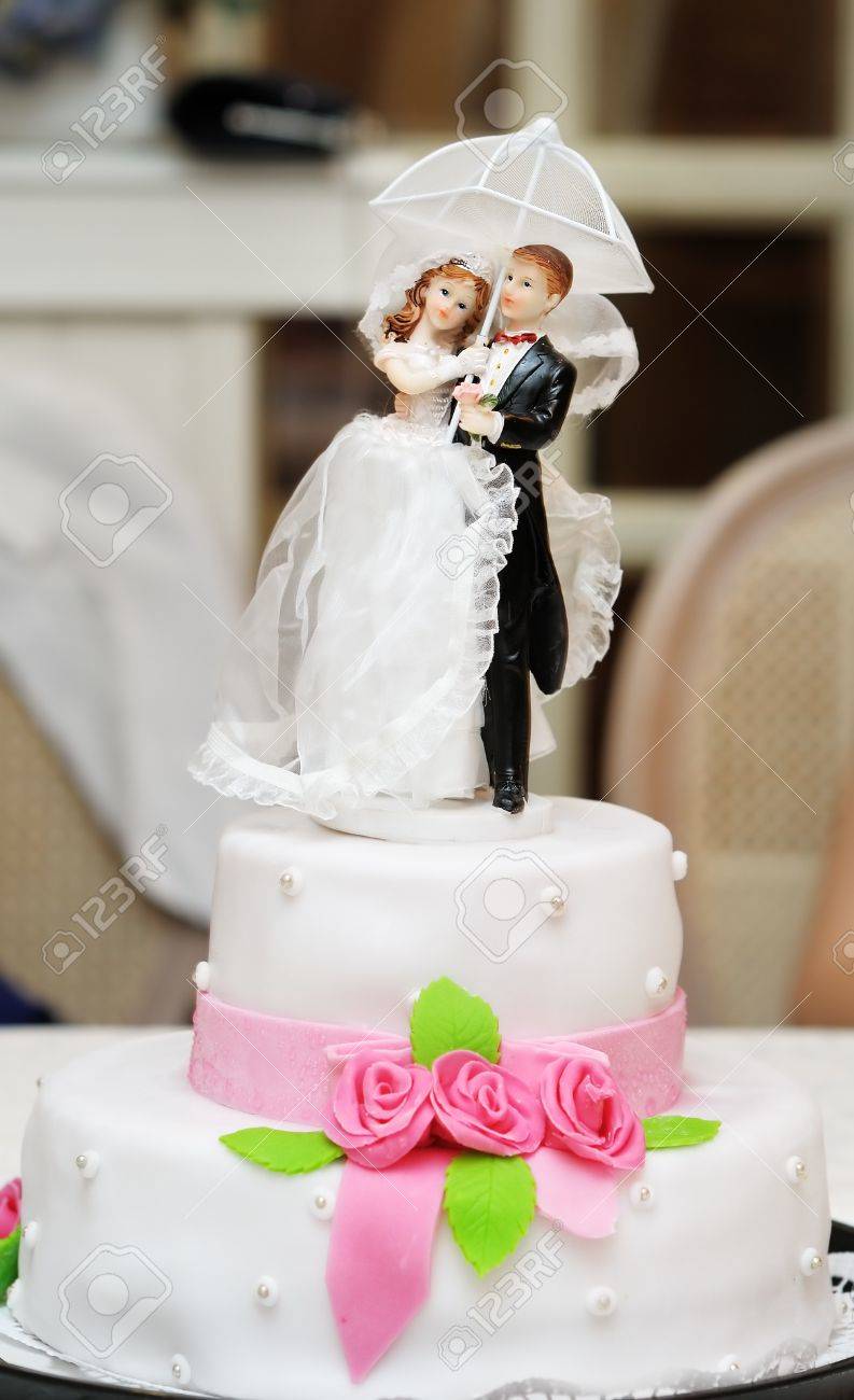 Figurines on top of wedding cake with roses decorations - 13443873 Figurines on top of wedding cake with roses decorations - 13443873