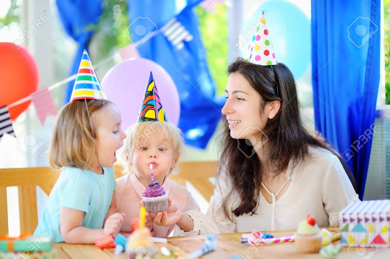 小さな子供とその母親は カラフルな装飾との誕生日パーティーとカラフルなデコレーション ケーキとケーキ を祝います お菓子 キャンディ 笛 送風機 ホルンとお祝い贈り物と家族 男の子と女の子の誕生日パーティー の写真素材 画像素材 Image