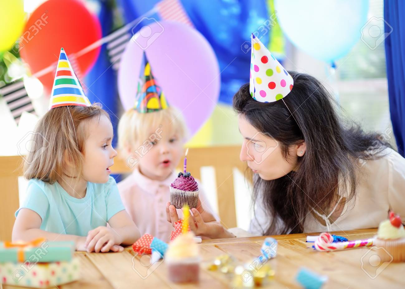 小さな子供とその母親は カラフルな装飾との誕生日パーティーとカラフルなデコレーション ケーキとケーキを祝います お菓子 お菓子やお祝い贈り物と家族 男の子と女の子の誕生日パーティー の写真素材 画像素材 Image