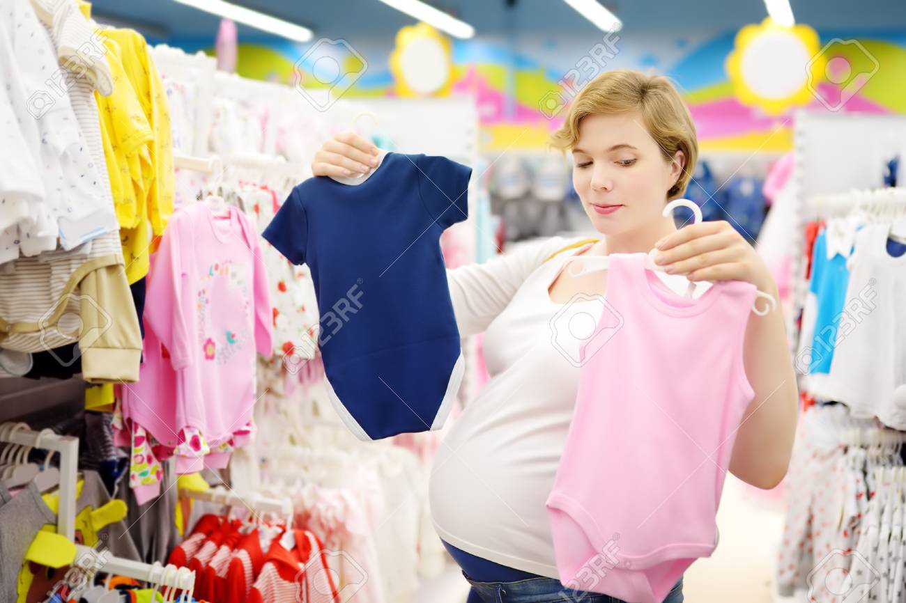 Young Pregnant Woman Choosing Pink Or Blue Clothes In The Store Stock Photo Picture And Royalty Free Image Image 123041291