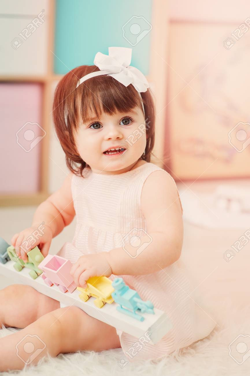 Cute Happy 1 Year Old Baby Girl Playing With Wooden Toys At Home
