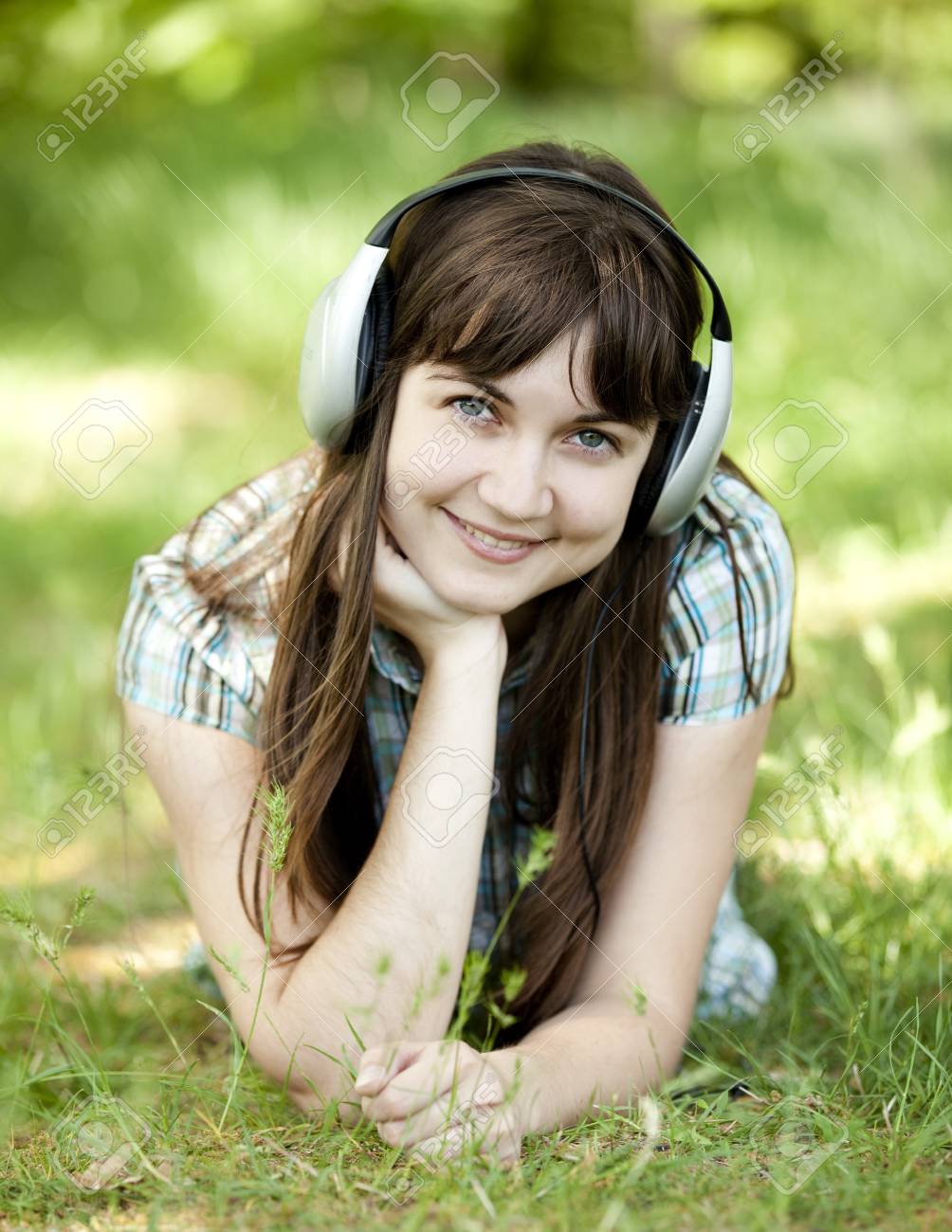 若い緑の春の草でヘッドフォンで女の子をファッションします の写真素材 画像素材 Image