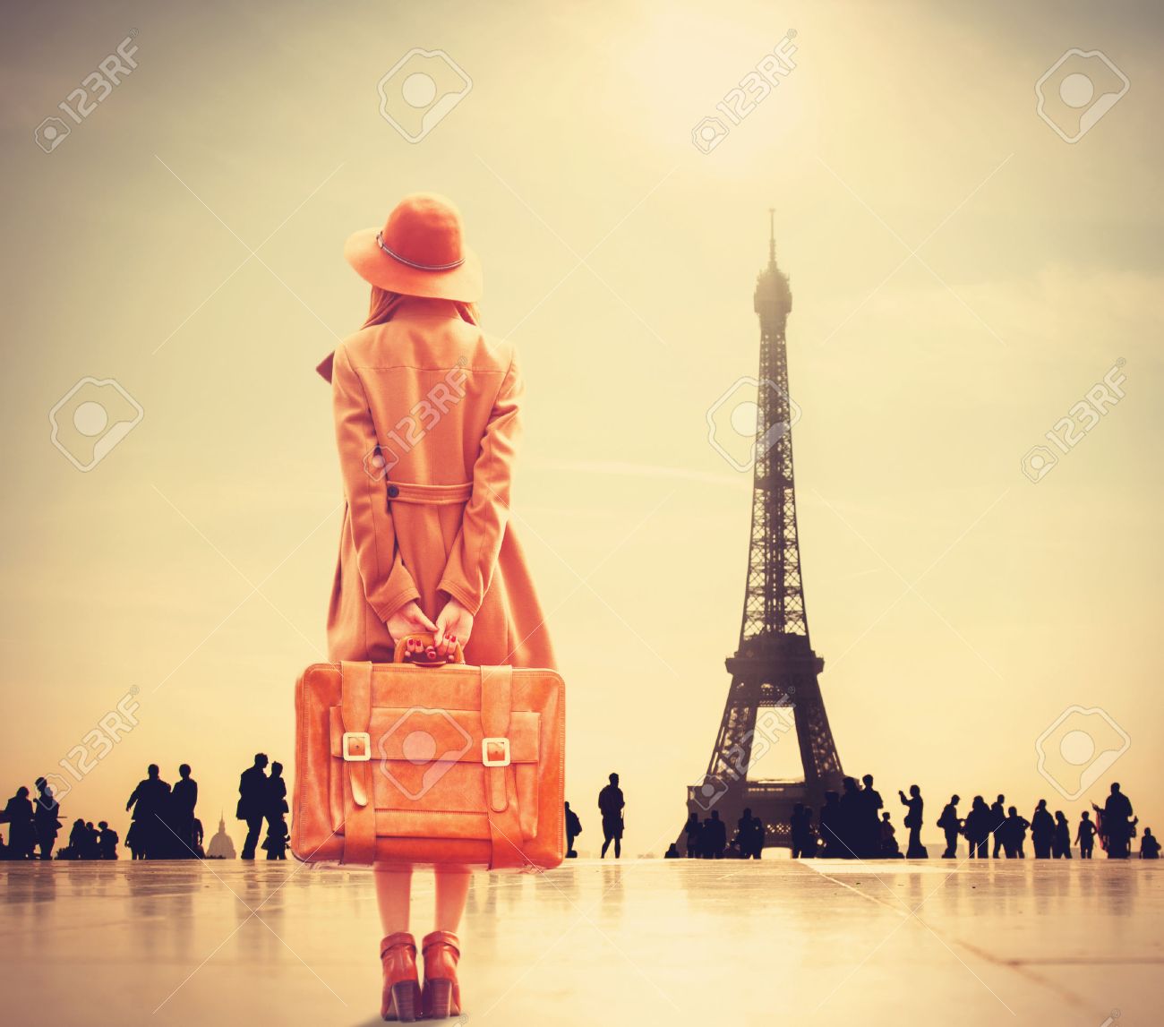 Redhead girl with suitcase on Eiffel tower background - 37324600 Redhead girl with suitcase on Eiffel tower background - 37324600