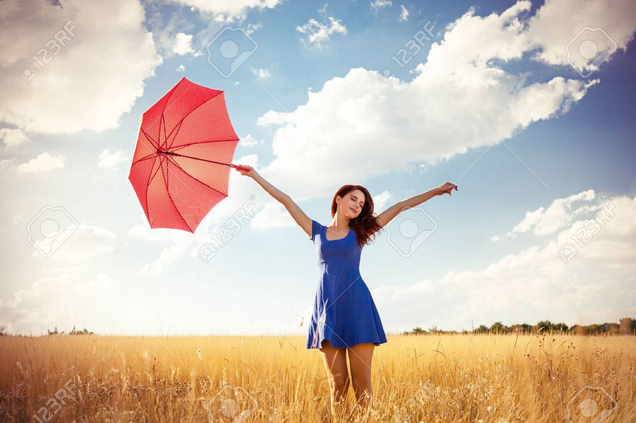 Beautiful redhead girl with umbrella at autumn countryside - 45605019 Beautiful redhead girl with umbrella at autumn countryside - 45605019