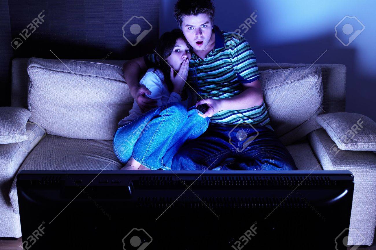 Couple on couch watching TV - shocked - 2038070 Couple on couch watching TV - shocked - 2038070