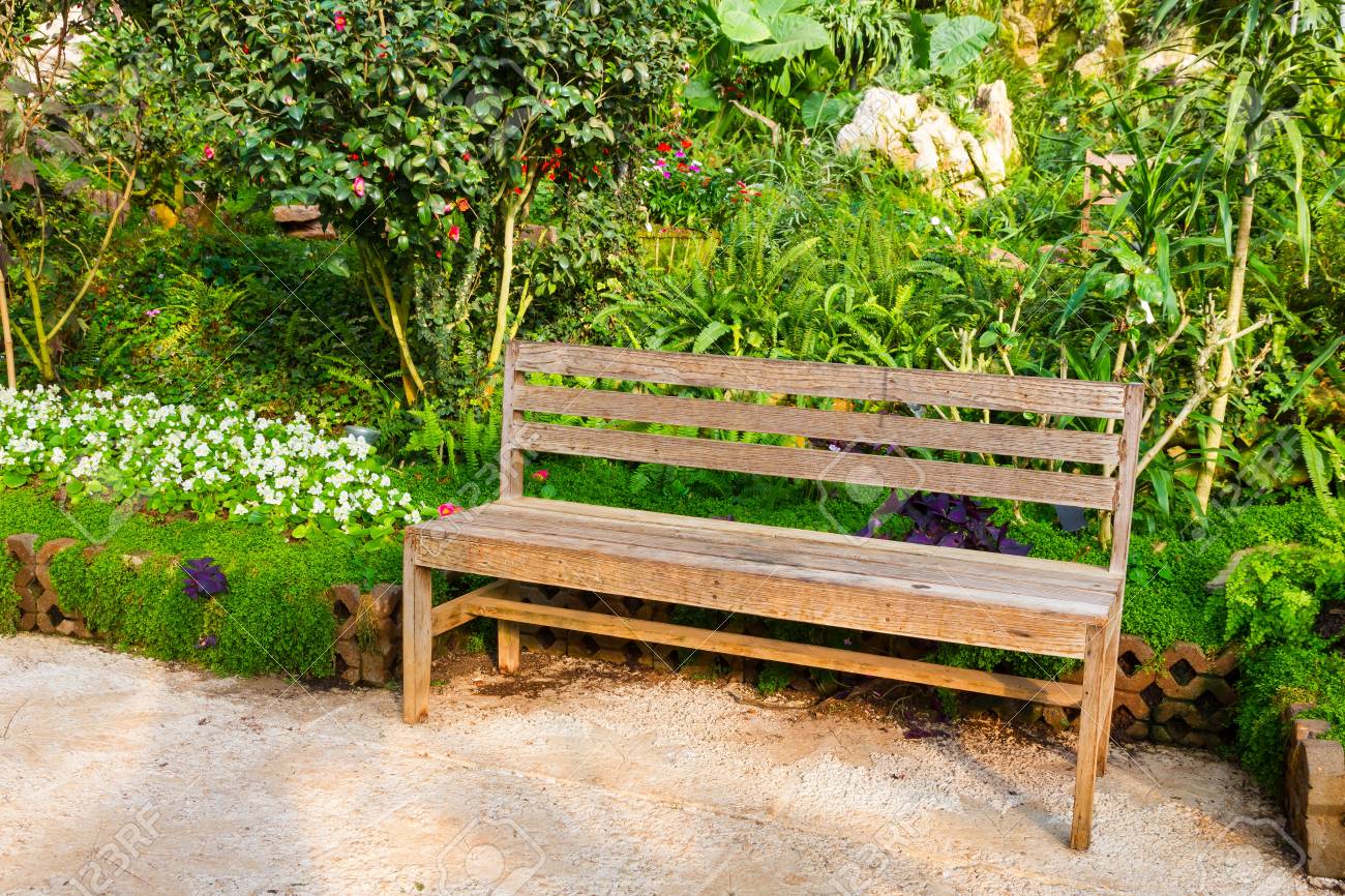 brown wooden bench in flower garden stock photo picture and royalty
