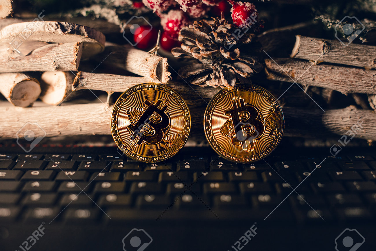 크리스마스 배경으로 키보드 위에 서 있는 조명된 비트코인 나무 배경 암호 크리스마스 선물에 크리스마스 시간에 두 개의 빛나는 황금  비트코인 가상 동전에 새해 복 많이 받으세요 로열티 무료 사진, 그림, 이미지 그리고