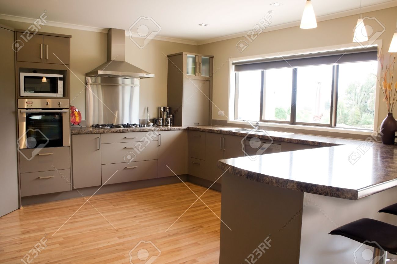 eine große, moderne küche mit edelstahl-zubehör und holzboden