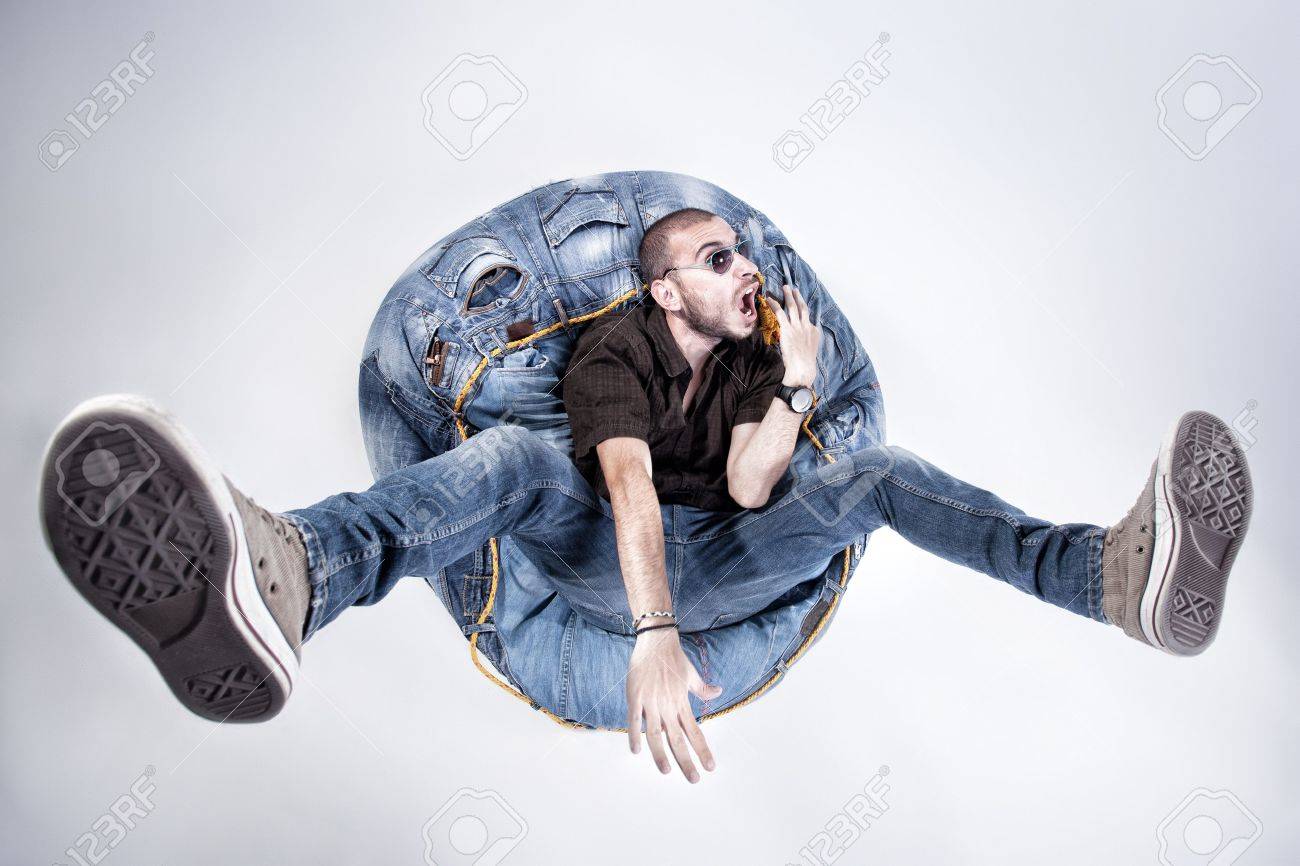 Funny Crazy Man Dressed In Jeans And Sneakers Standing On Denim Beanbag Stock Photo Picture And Royalty Free Image Image