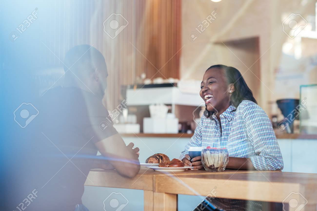 カフェに座っている間 若いアフリカのカップルが一緒にうっとりする の写真素材 画像素材 Image カフェに座っている間 若いアフリカのカップルが一緒にうっとりする の写真素材 画像素材 Image
