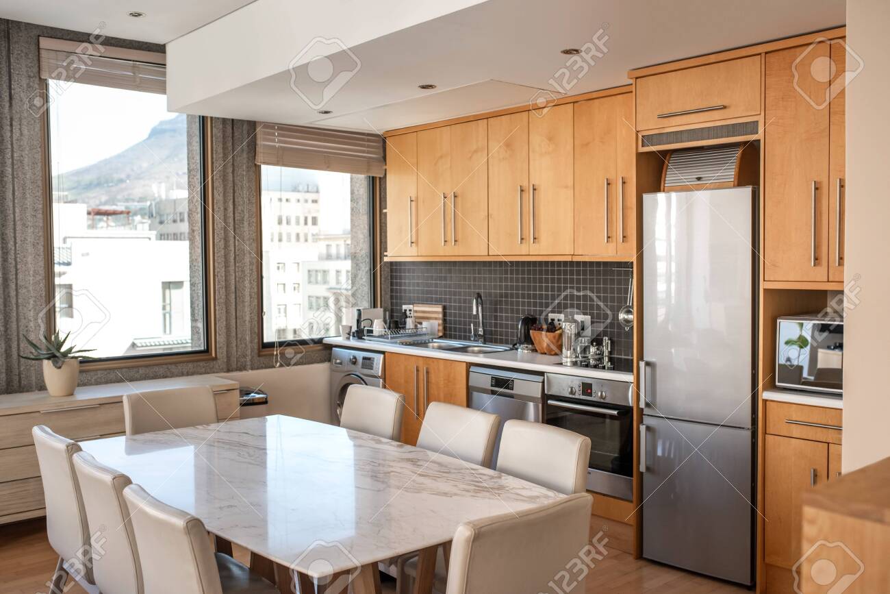 interior of the kitchen of a small apartment with dining table chairs and  various appliances