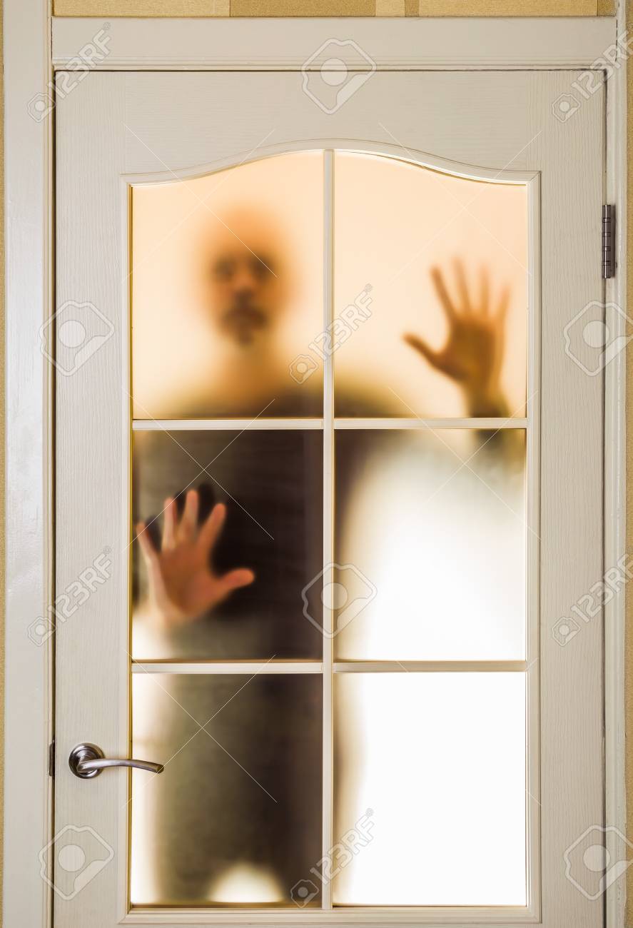 Silueta De Un Hombre Desconocido En Negro Visto Detrás De Una Puerta De Vidrio Cerrado, Como Un Fantasma O Un Extranjero Fotos, Retratos, Imágenes Y Fotografía De Archivo Libres De Derecho. Image