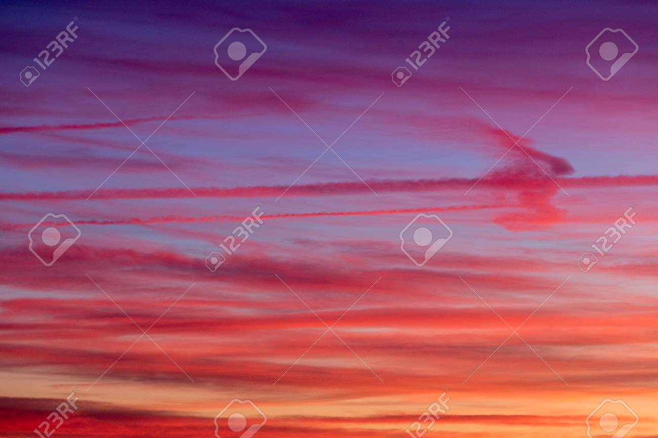 clouds and jet vapor trails creating beautiful colorful texture vapor trails