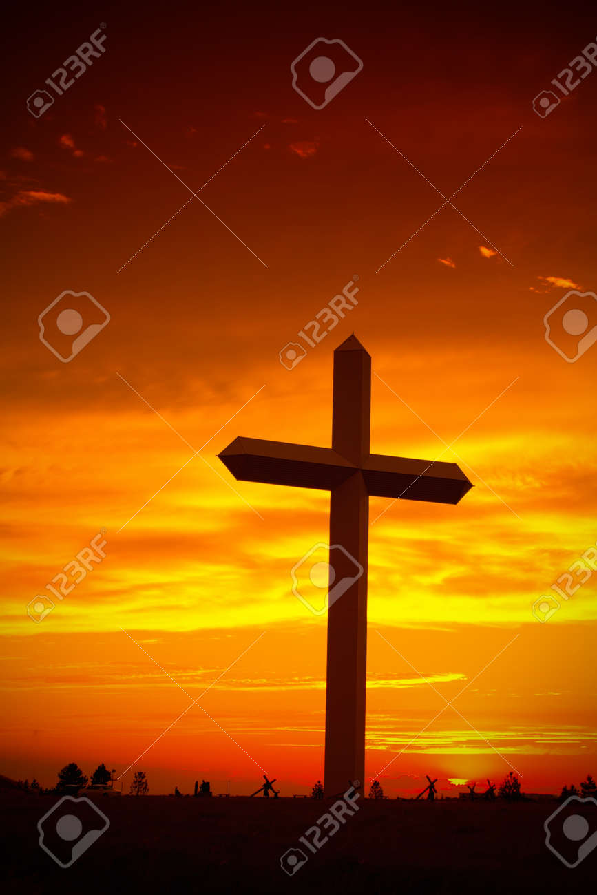 Huge christian cross silhouette during sunset against sky - 9002698 Huge christian cross silhouette during sunset against sky - 9002698