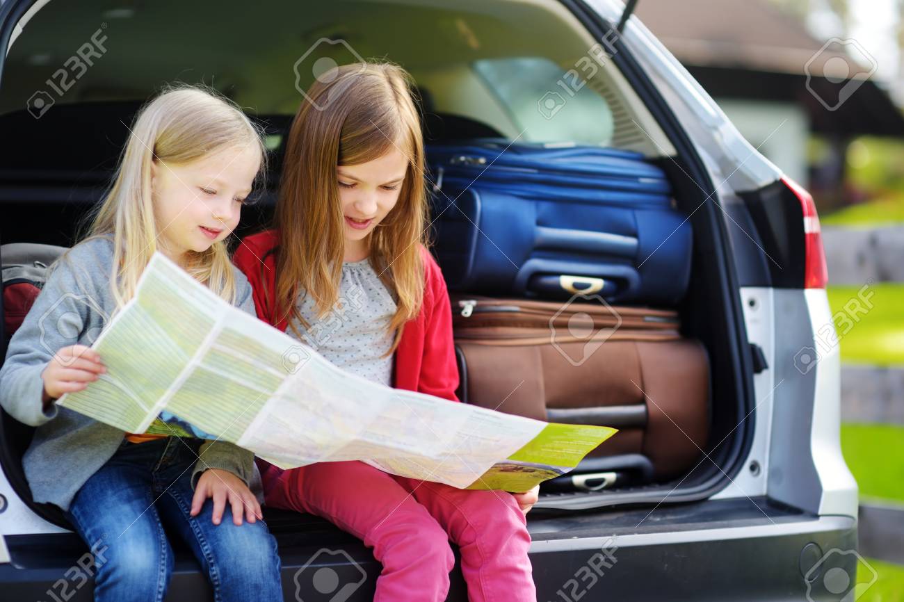 二人の愛らしい少女は 両親と旅行に行く準備ができてください 地図を調べる車の中に座って子供たち 子供たちと車で旅行します の写真素材 画像素材 Image