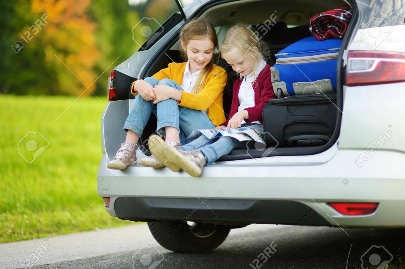 二人の愛らしい少女は 両親と旅行に行く準備ができてください 地図を調べる車の中に座って子供たち 子供たちと車で旅行します の写真素材 画像素材 Image