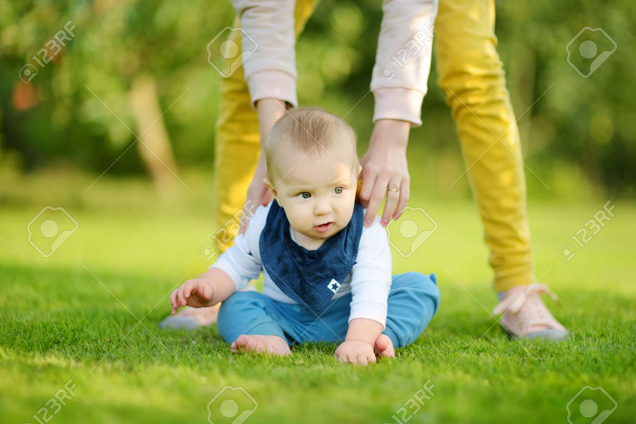 Cute five months old baby boy learning how to sit up without support. Baby during floortime. Adorable little child trying to sit up on his own. - 166230268 Cute five months old baby boy learning how to sit up without support. Baby during floortime. Adorable little child trying to sit up on his own. - 166230268