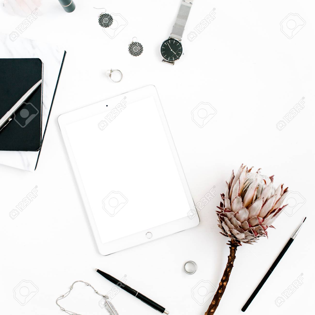 空白の画面のタブレット プロテアの花 ノート 時計 白い背景のフェミニンなアクセサリーとブロガーやフリーランスのワークスペースです ミニマルなフラット横たわっていた トップ ビューには ホーム オフィスの机が飾られています の写真素材 画像素材 Image