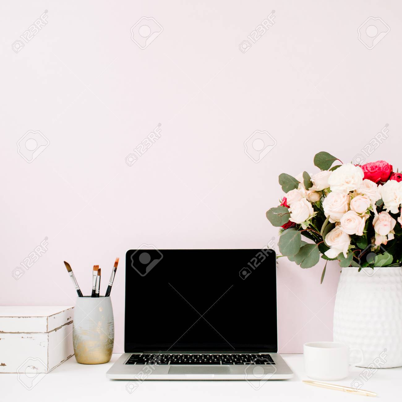 空白の画面のラップトップ 美しいバラ ユーカリ花束 淡いパステル ピンクの背景の前で白いビンテージ棺とホーム オフィスの机 ブログ ウェブサイトやソーシャル メディアの概念 の写真素材 画像素材 Image