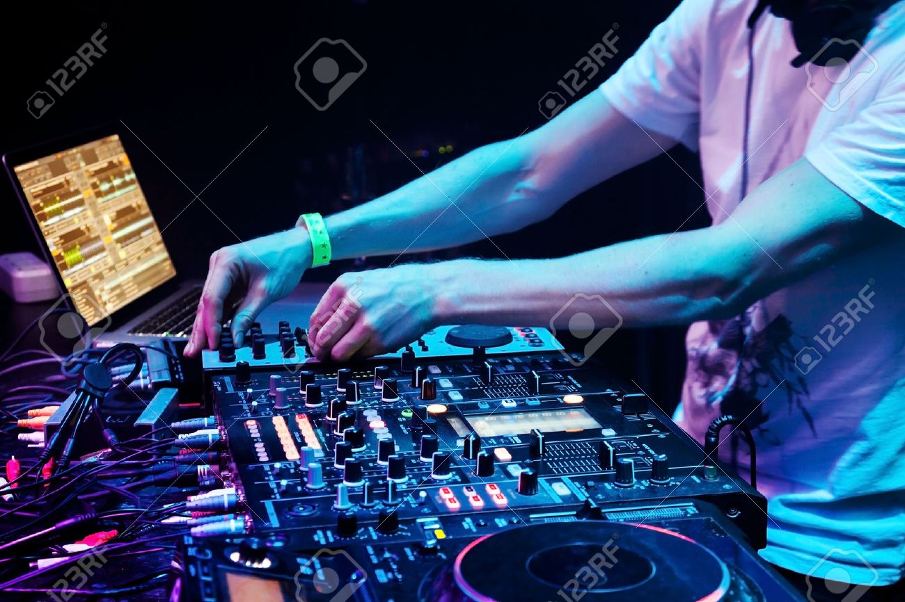 dj mixes the track in the nightclub at party headphones in