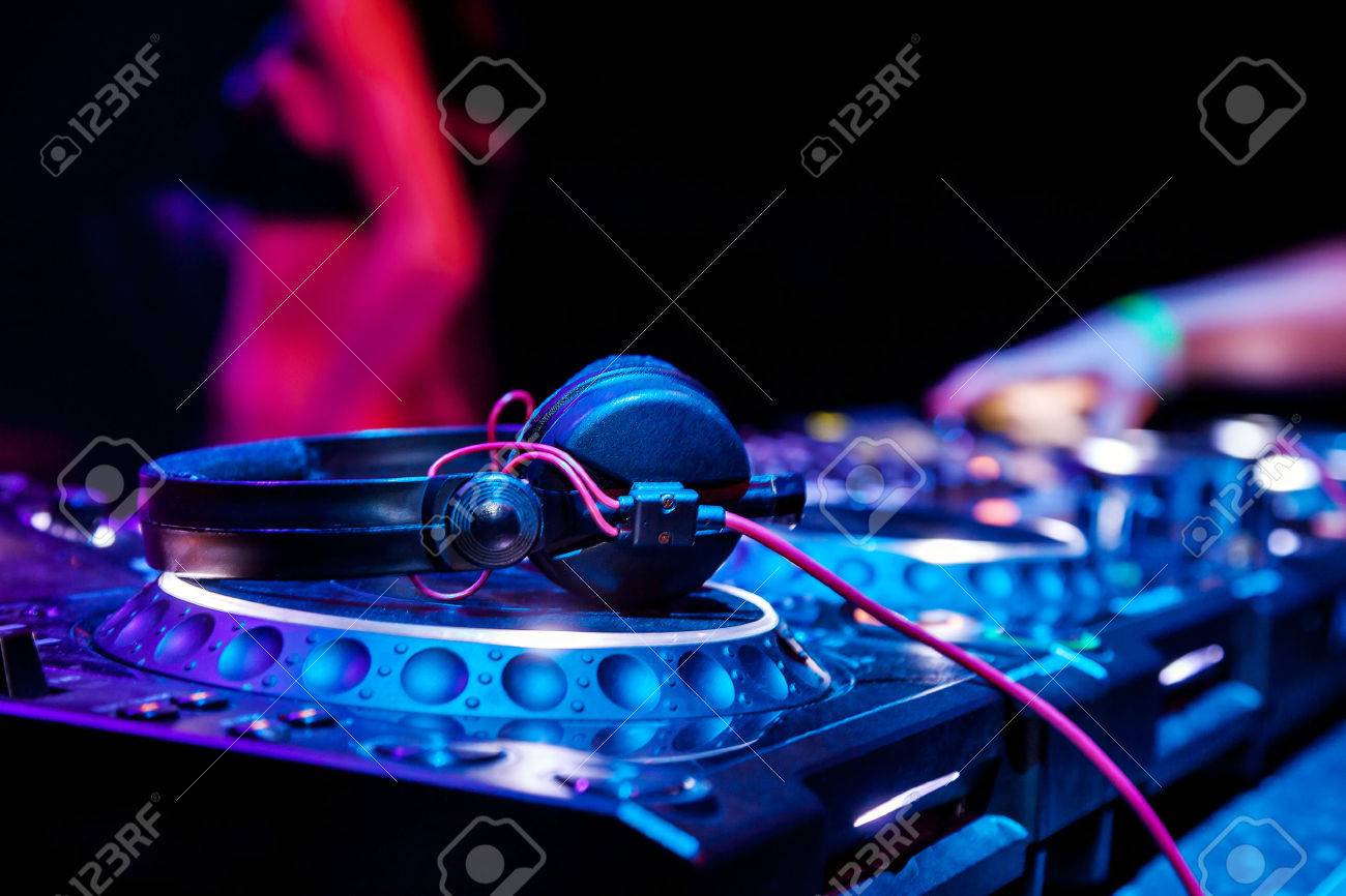dj mixes the track in the nightclub at party headphones in