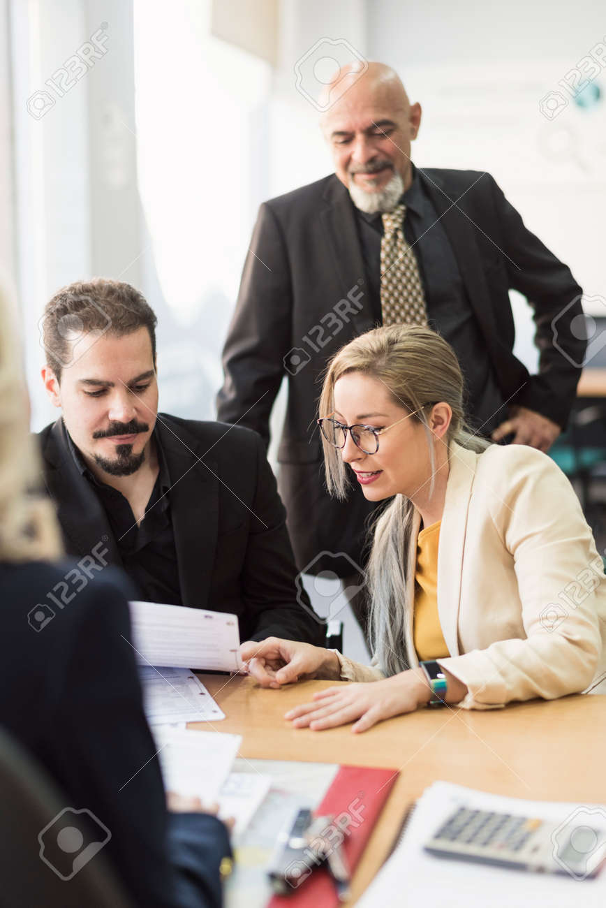 Group of workers in office looking papers in workplace - 121378583 Group of workers in office looking papers in workplace - 121378583
