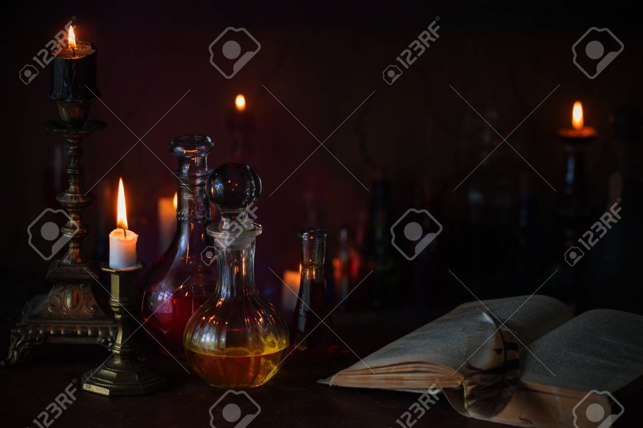 Magic potion, ancient books and candles on dark background - 94217531 Magic potion, ancient books and candles on dark background - 94217531