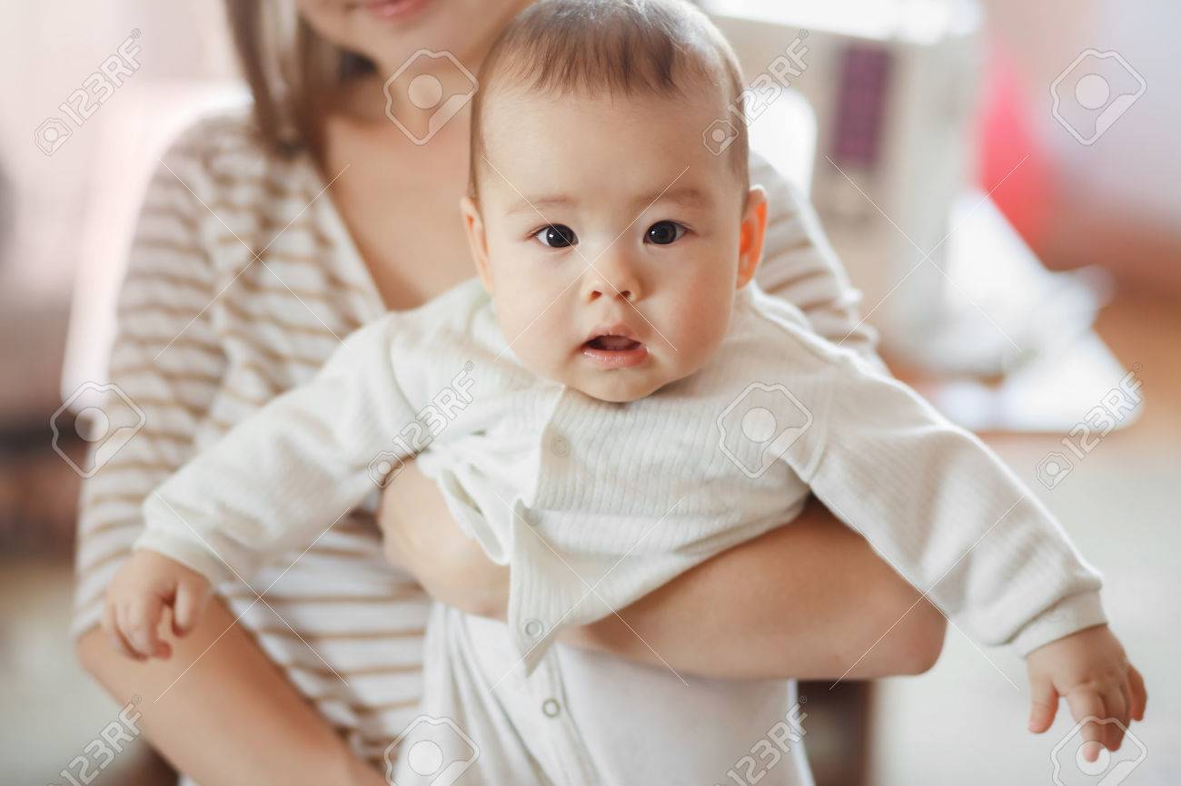 Stock photo the cute little baby boy in the arms of mom on the air mother and infant infant care children and kids growing