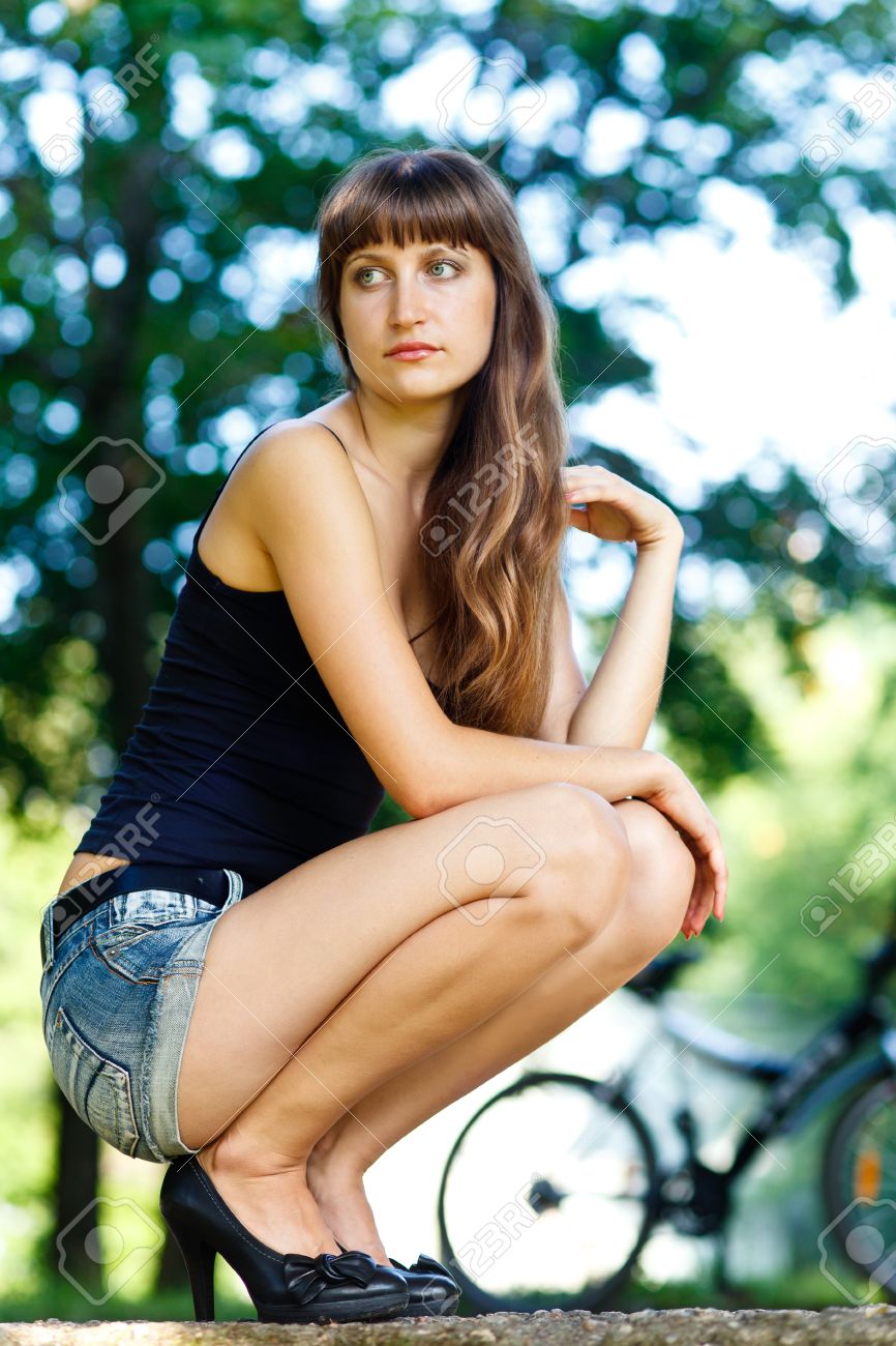 ジーンズのショート パンツと黒の上の公園で座っている白人の長い髪の少女 の写真素材 画像素材 Image