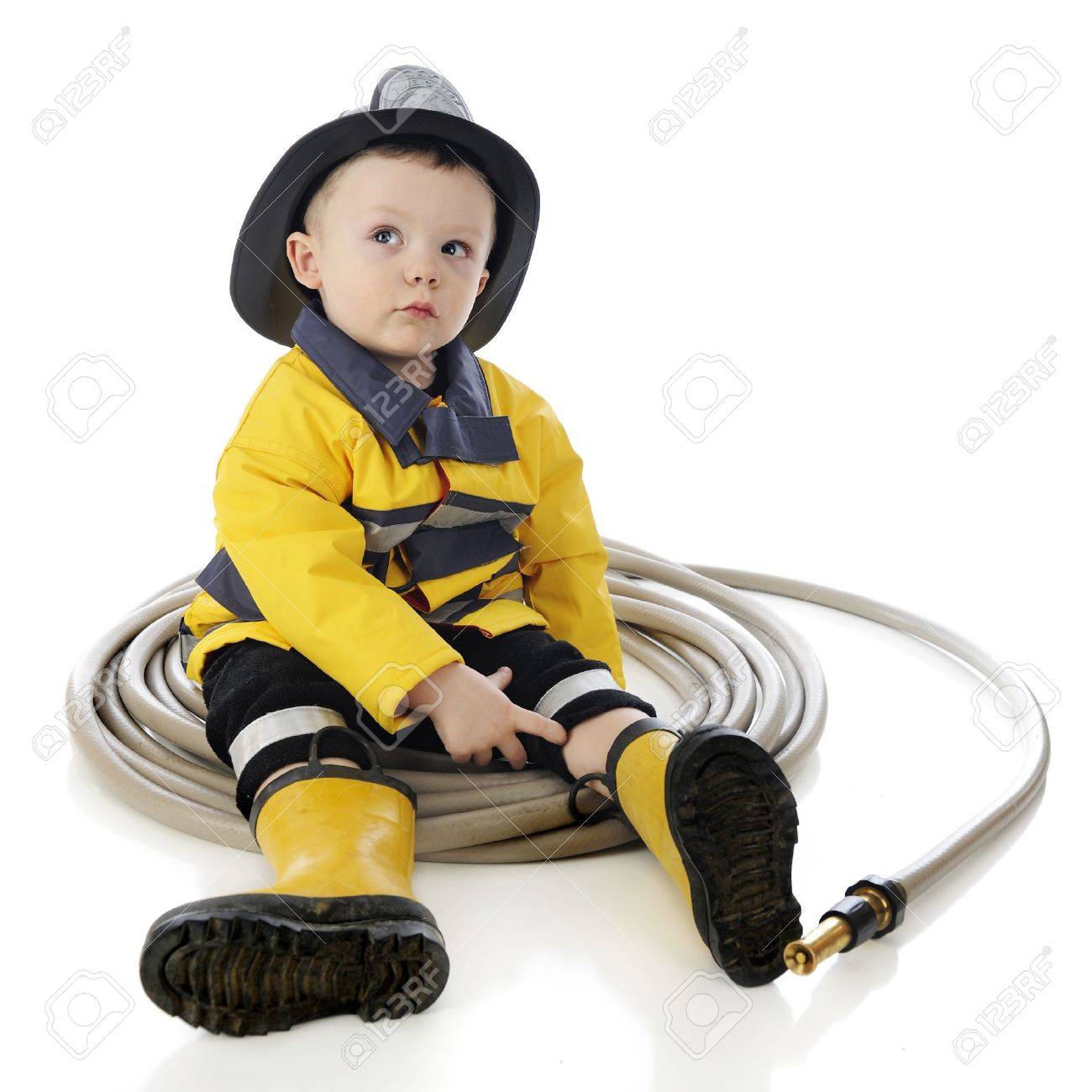 Un Bebe Adorable Pompier Se Trouve Dans Un Cercle De Tuyau Sur Un Fond Blanc Banque D Images Et Photos Libres De Droits Image