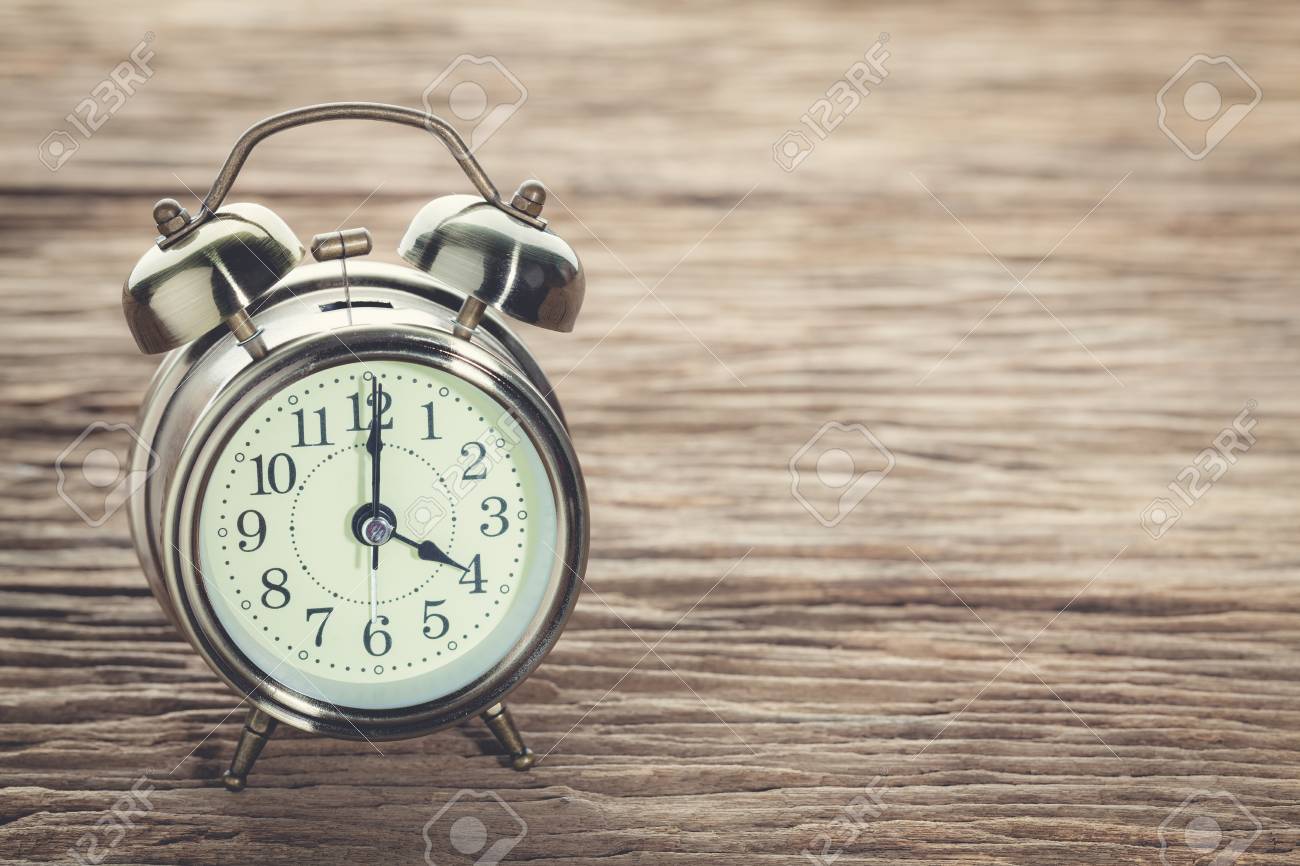 clock at 4 pm o clock in the afternoon with vintage style alarm