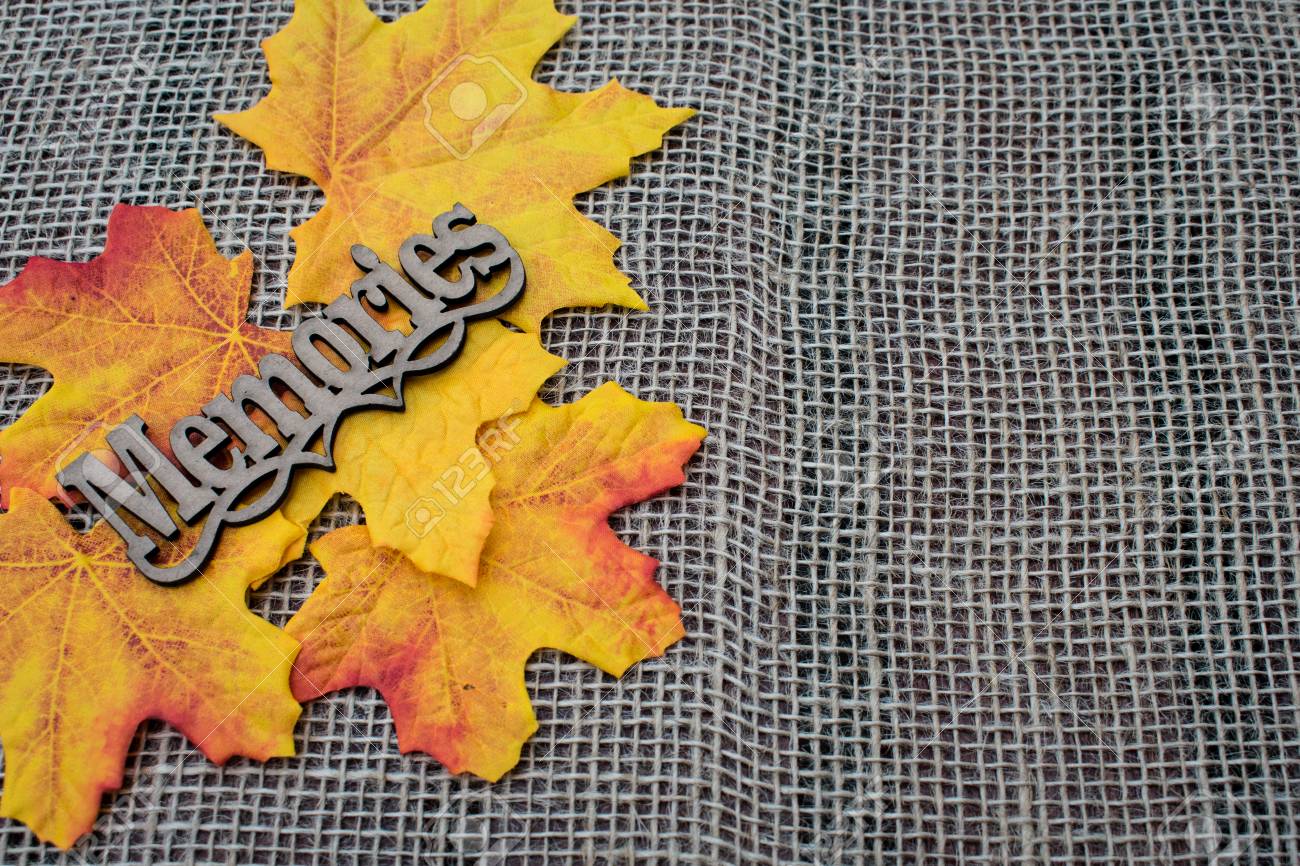 autumn leaves decoration in burlap background with memories tag