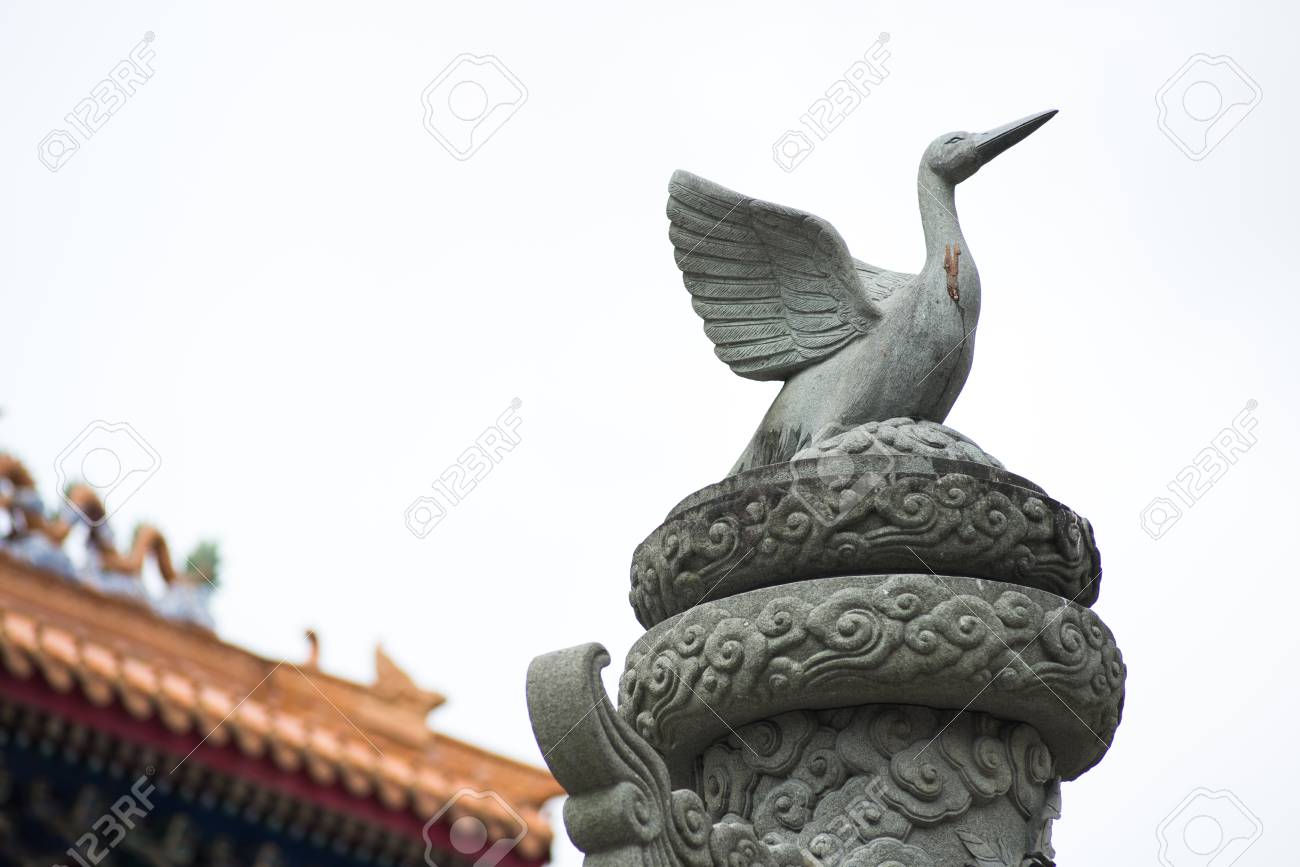 Close up Bird sculpture on top of stone pole in smoke sky - 88203720 Close up Bird sculpture on top of stone pole in smoke sky - 88203720