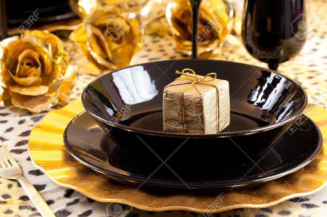 Golden Gift Box In A Black And Gold Table Setting With Gold Roses ... Golden Gift Box In A Black And Gold Table Setting With Gold Roses ...