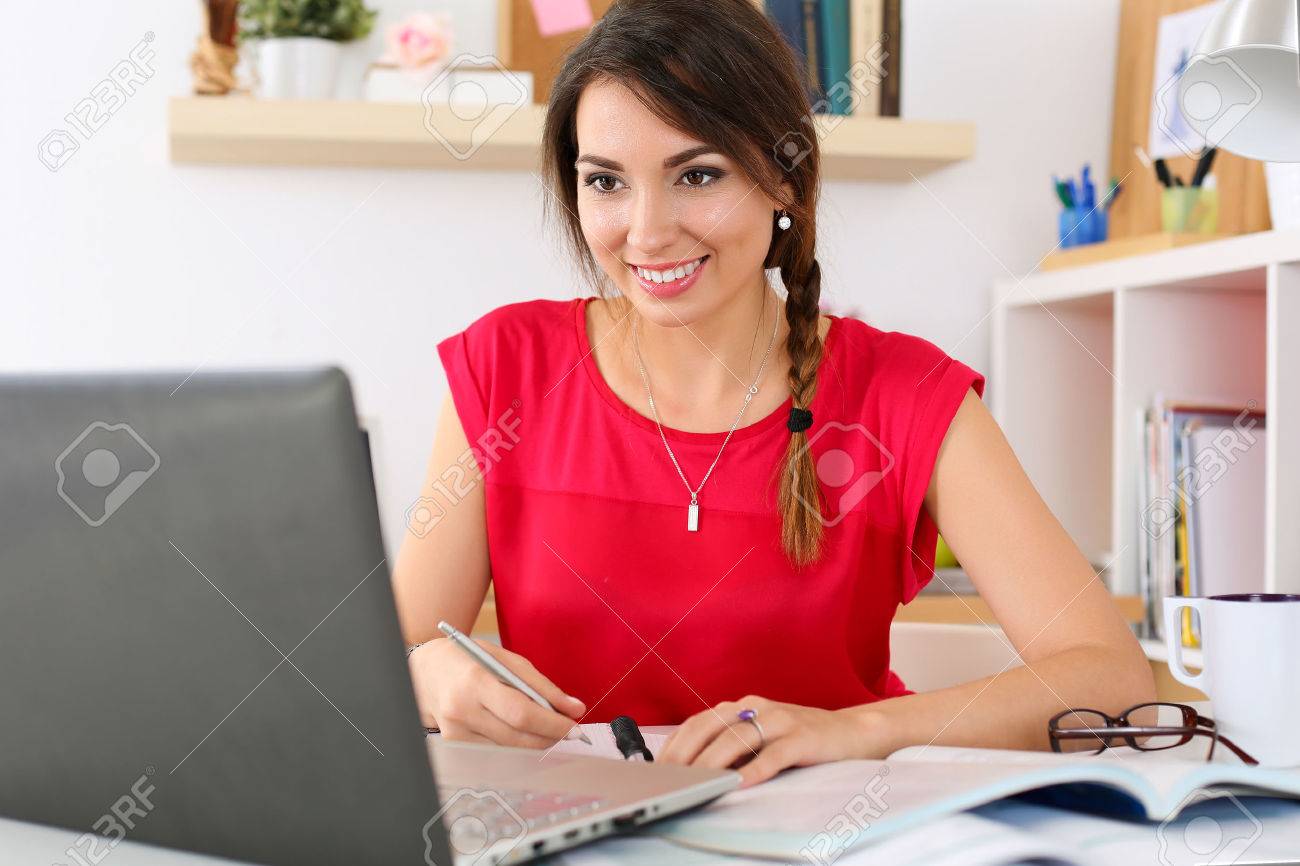 Beautiful smiling female student using online education service. Young woman in library or home room looking in laptop display watching training course. Modern study technology concept - 47986749 Beautiful smiling female student using online education service. Young woman in library or home room looking in laptop display watching training course. Modern study technology concept - 47986749