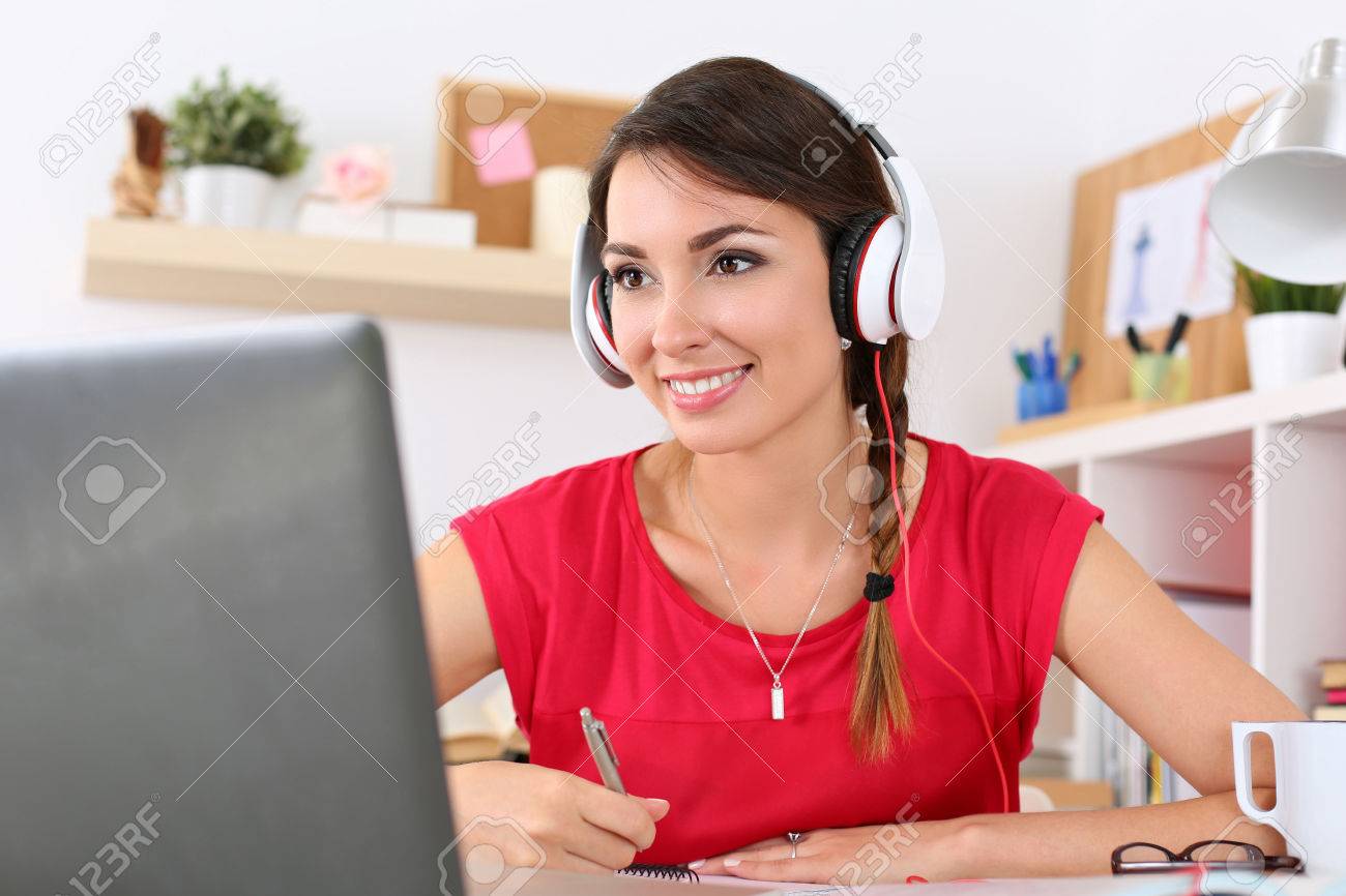Beautiful smiling female student using online education service. Young woman looking in laptop display watching training course and listening it with headphones. Modern study technology concept - 50962909 Beautiful smiling female student using online education service. Young woman looking in laptop display watching training course and listening it with headphones. Modern study technology concept - 50962909